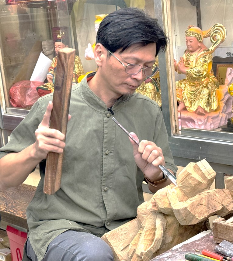 Carving statues of gods usually requires fixing the wood with feet clamped.